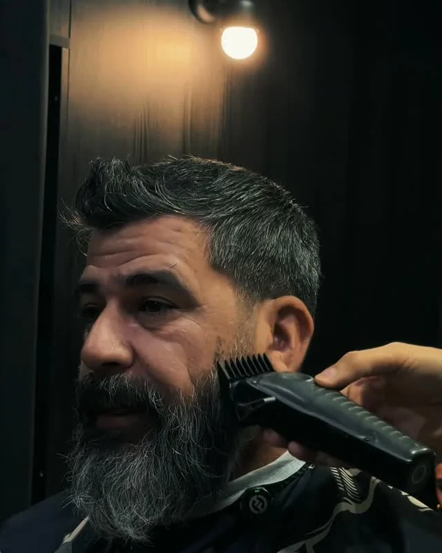 Barbero de Bellmont perfilando una barba con máquina
